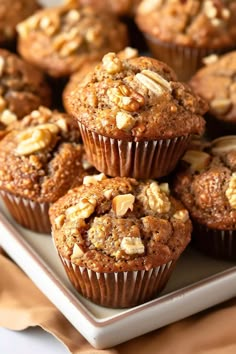 several muffins on a white plate with some nuts in the middle and another muffin next to it