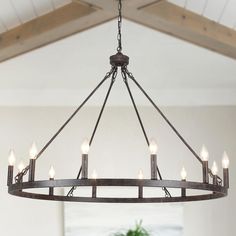 a chandelier with six lights hanging from it's center beam in a living room