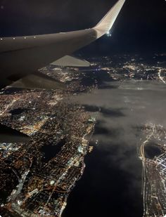 an airplane wing flying over the city lights