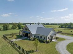 an aerial view of a farm with a barn and horse pen in the foreground