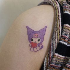 a person with a small tattoo on their arm that has an image of a cat holding a heart