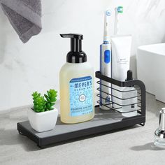 a bathroom sink with soap, toothbrushes and other personal care items on it