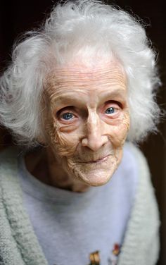 an old woman with white hair and blue eyes is looking at the camera, in spanish