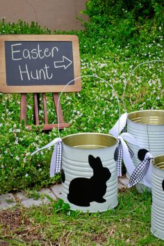 three buckets decorated with black and white bunny silhouettes are sitting in front of a sign that says easter hunt