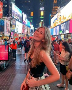 a woman standing in the middle of a busy city street