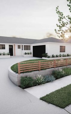 an artist's rendering of a modern house with grass and shrubs in the front yard