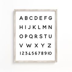 a black and white poster with the alphabet in it's frame on a wall