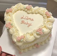 a heart shaped cake with the words baby boy written in frosting and flowers on it