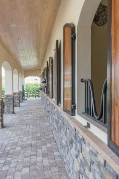 the walkway is lined with windows and doors on both sides of the building, along with brick pavers flooring