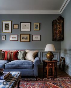 a living room filled with furniture and framed pictures on the wall above it's couch