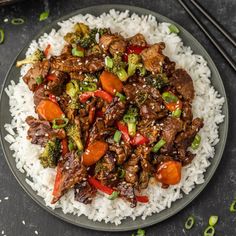 beef and broccoli stir fry over rice on a plate