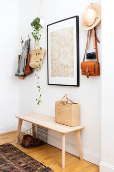 a wooden bench sitting next to a wall with pictures hanging on it's side