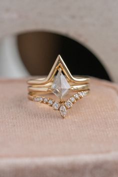 a close up of a gold ring with an arrow on the front and two diamonds on the back