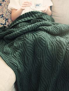 a woman sitting on a couch holding a cup