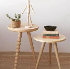 two small tables with books and a plant on them