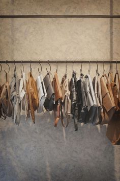 a rack filled with lots of different types of purses hanging from it's hooks