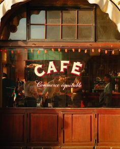 the front window of a cafe with people standing outside