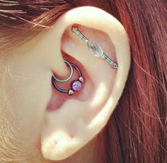 a close up of a person's ear with some piercings on it