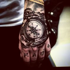 a person with a tattoo on their hand and a clock tattooed on the wrist is shown