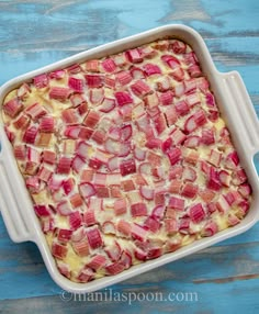 a casserole dish with ham and cheese in it on a blue wooden table