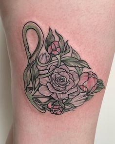 a woman's thigh with flowers on it and a swan tattoo design in the middle