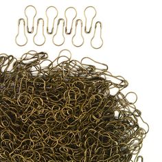 a bunch of gold colored paper clips sitting on top of each other