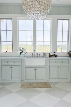 a large kitchen with white cabinets and windows