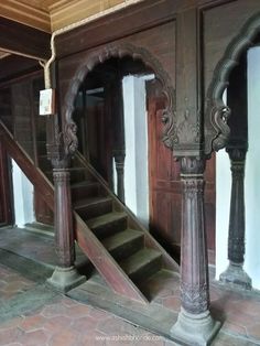 an old building with wooden stairs and carved pillars