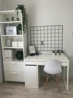 a white desk and chair in front of a book shelf with books on it, next to a potted plant