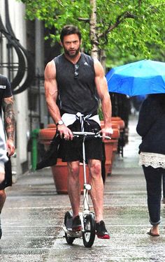 a man riding a scooter with an umbrella