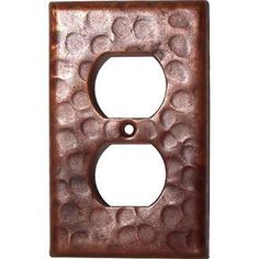 an iron outlet cover with circles on the front and back of it, which is brown