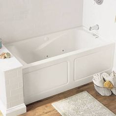 a white bath tub sitting on top of a wooden floor