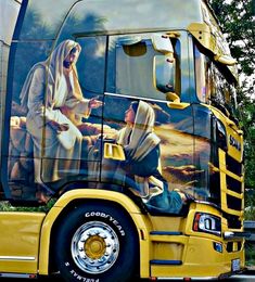 a yellow semi truck with the image of jesus on it's side