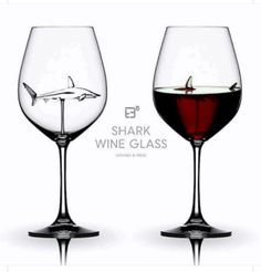 two wine glasses filled with red wine and a white shark in the glass are shown