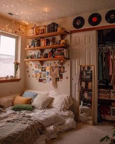 a bed sitting under a window next to a book shelf filled with lots of books