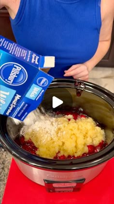 a woman pouring milk into a crock pot filled with food