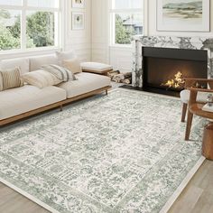 a living room filled with furniture and a fire place next to a white couch on top of a hard wood floor