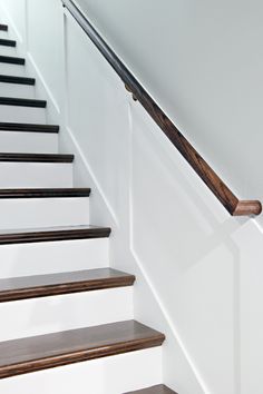 some stairs with wooden handrails and white walls