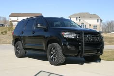 a black suv parked in front of a house