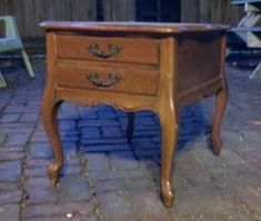 an old wooden table with two drawers on the top and one drawer open to reveal something