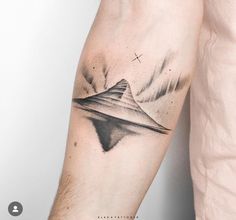 a man's arm with a mountain tattoo on it