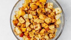 a glass bowl filled with potatoes on top of a table