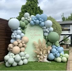 an arch made out of balloons in the shape of a wreath on top of grass