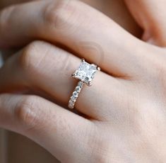 a woman's hand with a diamond ring on it