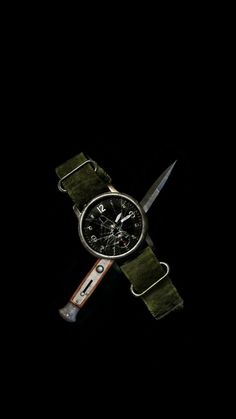 a watch that is sitting on top of a green strap with black dial and white hands