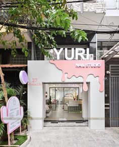 the entrance to yurh nail studio with pink and white paint dripping down it's walls