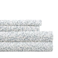 three sheets with blue and white floral designs on the bottom, one is rolled up