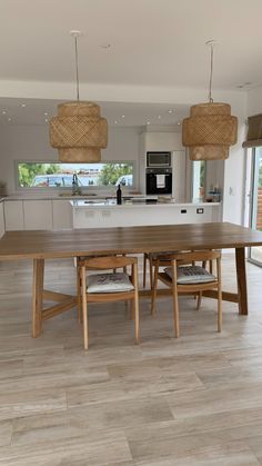 a large wooden table sitting in the middle of a kitchen next to an open floor plan