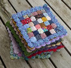 a stack of colorful cloths sitting on top of a wooden table next to each other