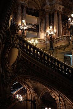 an ornate staircase with chandeliers in a building